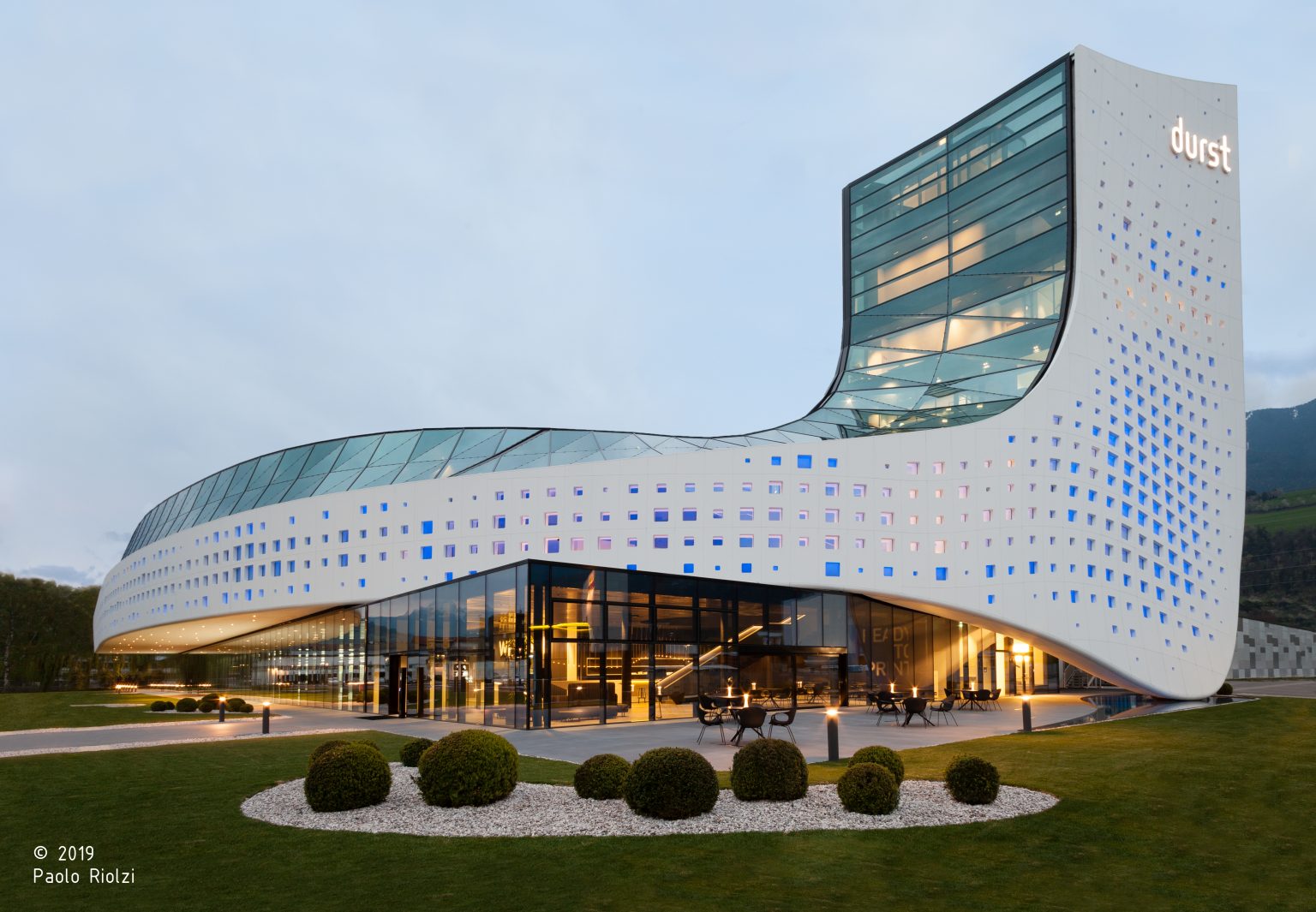 Durst Group Headquarters in Brixen: der gesamte Neubau mit Turm in der Abenddämmerung